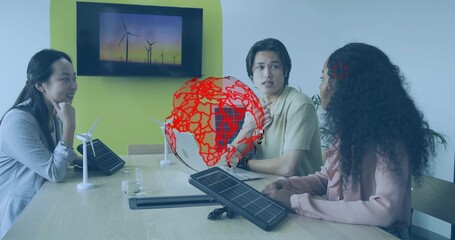 Reviewing renewable energy models, team wearing suits collaborating in boardroom with globe graphic