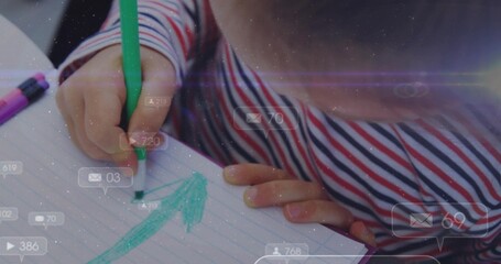 Drawing child's hands marking arrow on lined paper at desk, with green marker and digital overlays