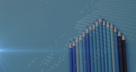 Showcasing fifteen blue-shaded pencils ascending on blue tabletop, with lens flare, copy space