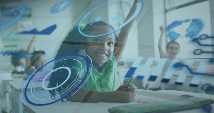 Smiling girl in green t-shirt holding pencil above notebook at school desks, with digital charts