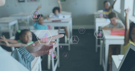 Pointing teacher's hand interacting with hexagonal icons in classroom, with students raising hands