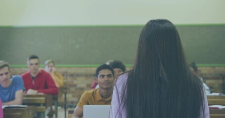 Teenage female student presenting in high school classroom with desks laptop chalkboard, copy space