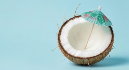 Fresh tropical coconut halved open showing white flesh and water with green mint leaves