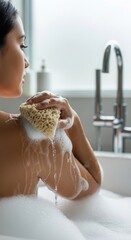 Woman's Arm and Loofah in a Foamy Bathtub. Naturalistic Self-Care Ritual with Soap Suds. Soft Light on a Relaxing Bath Time Scene.