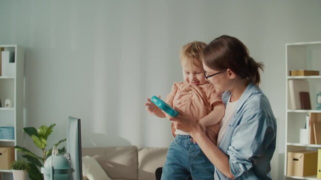 Work-Life Balance. Smiling Mother Pauses Remote Job to Enjoy Playtime With Toddler, Showing Family Bonding and Harmony Between Work and Parenting at Home