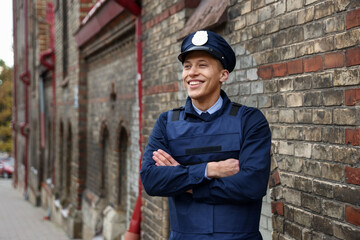 Portrait of smiling police officer on city street. Space for text