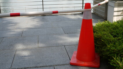 Construction safety cones arranged as a barricade at an active job site, with a worker in the...