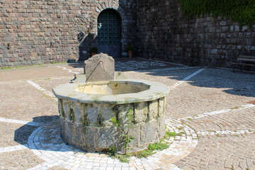 Antica fontana circolare di pietra e marmo con meridiana a Torre Alfina