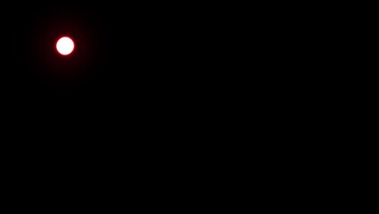 Abstract glowing red light orb on a dark black background with subtle texture and soft focus effect