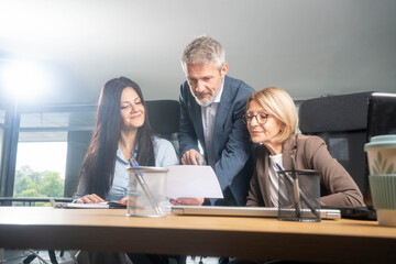 Multiethnic team discussing business strategy around laptop creative office environment collaboration