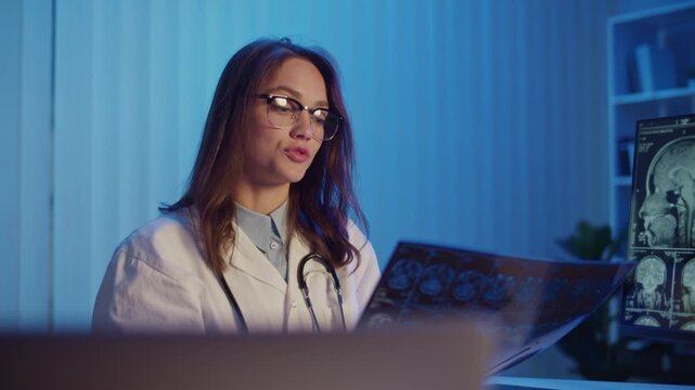 Breakthrough Research. Female Doctor Holds Brain MRI Scans During A Medical Report, Presenting New Findings On Stroke Diagnosis And Treatment, Highlighting Innovation And Progress In Modern Healthcare
