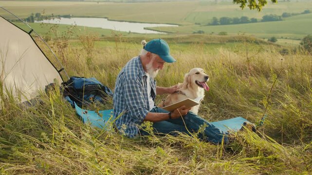 Quiet Retirement, Mindful Aging, Pet Bonding. Senior Man Sits Beside Tent With His Dog and Reads a Book in Nature. A Peaceful Moment of Reflection, Companionship, and Slow Outdoor Living