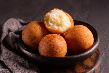 Colombian food buñuelos in rustic bowl – traditional Latin American snack with soft interior and warm lighting