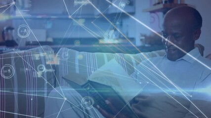 Senior man settling back with book in lounge, initiating technology network overlay while reading - Powered by Adobe