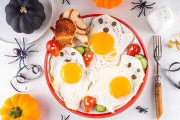 Halloween breakfast food, ghost shaped fried eggs, toasts and salad