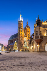 St Mary's church and Cloth Hall fragment on snow covered Main Square in winter Krakow, illuminated in the dawn