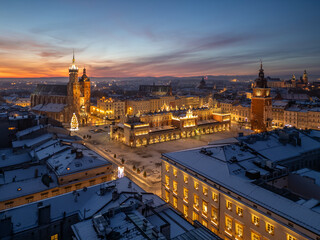 Aerial late night / dawn view of snow covered Main Square with St Mary's church and Cloth Hall with Christmas Tree in Krakow, Poland