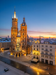 St Mary's church and Christmas tree on the snow covered Main Square in the winter dawn, Krakow, Poland