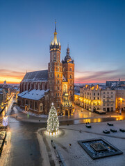 St Mary's church and Christmas tree on the snow covered Main Square in the winter dawn, Krakow, Poland