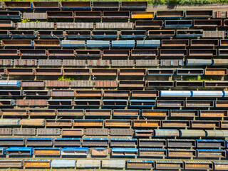 Many railroad cars (rail cars) of different cargo types on multiple parallel railway tracks, seen from above the railway station