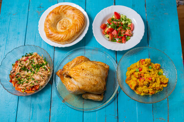 Couscous with dried hands and turmeric, grilled whole chicken, flatbread, and vegetable salad