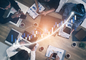 A group of diverse professionals engage in a collaborative business meeting, utilizing technology and data analysis to drive strategic decisions in a modern office environment. Impute