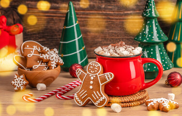 Warm Christmas spirit concept with red mug of hot chocolate, marshmallows, and gingerbread cookies symbolizing coziness, joy, and festive comfort
