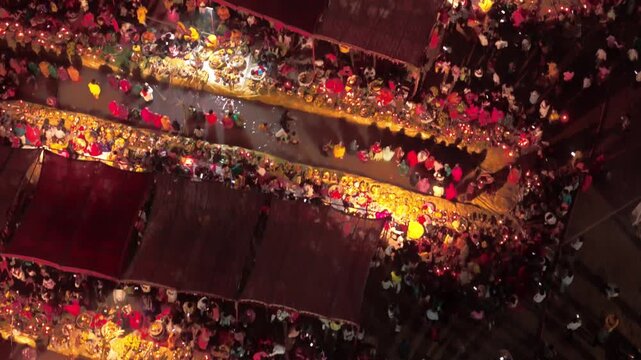 Drone aerial view of devotees standing in water during Usha Arghya at Chhath Puja in Bihar. Early morning prayers with diya lights shining.