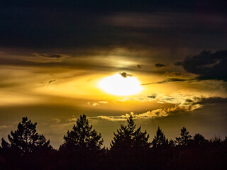 Sonne trinkt durch dunkle Wolken