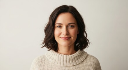 Young caucasian female smiling in cozy knit sweater against neutral background
