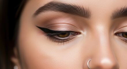 Close-up of female eye with winged eyeliner and nose piercing