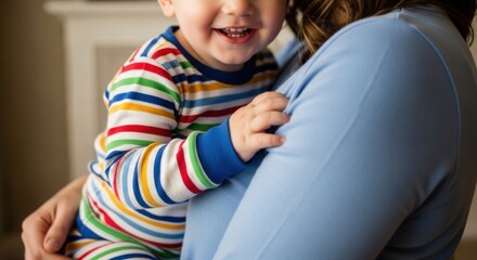 Smiling child in striped pajamas hugging female adult indoors