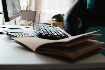 Home office workspace with calculator, keyboard and notebook