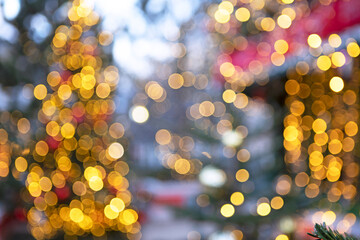 Christmas trees outside are out of focus. Christmas texture for postcards. Garland with lights on the Christmas tree. A place for advertising.