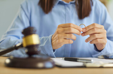 Wedding ring near judges gavel shows divorce case, emotional breakup and family separation. It highlights conflict, stress and paperwork during legal trial. Separation is a painful final step.
