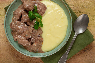 liver beef stroganoff with mashed potatoes, table setting in green tones, homemade,