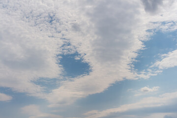 Beautiful cloud patterns in a clear blue sky above a serene landscape
