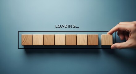 Hand placing last wooden block on loading bar, progress concept