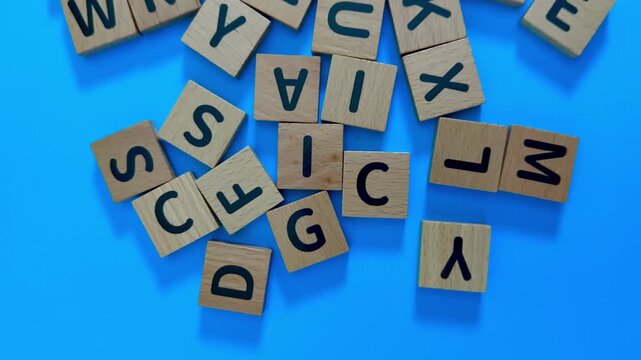 Scattered Wooden Letter Tiles Forming Words On Blue Surface