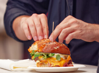 Close-up of a delicious cheeseburger at a street food festival in Prague. In the background, a man...