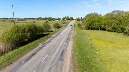 Car on a Rural Road in a Green Landscape