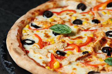 Tasty pizza with melted cheese and assorted toppings on a dark background. Perfect for menu, delivery or food promo.