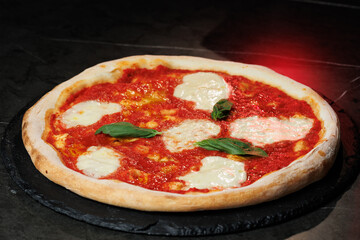 Tasty pizza with melted cheese and assorted toppings on a dark background. Perfect for menu, delivery or food promo.