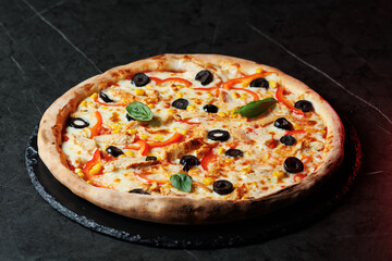 Tasty pizza with melted cheese and assorted toppings on a dark background. Perfect for menu, delivery or food promo.