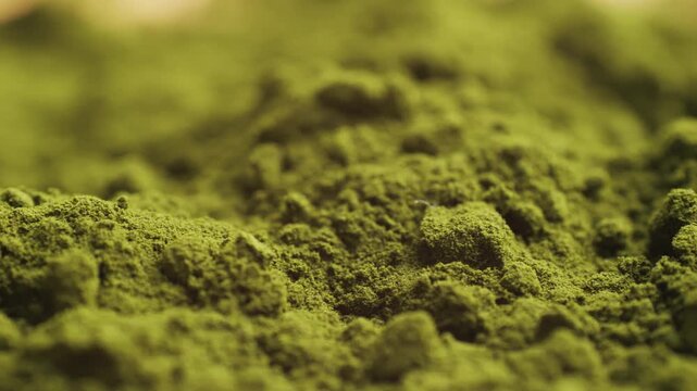 Green chlorella algae powder on a wooden spoon, top view. Healthy nutritional supplement.