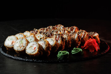 Assorted sushi rolls with fresh ingredients on a dark background. Ideal for restaurant, menu or Japanese food design.