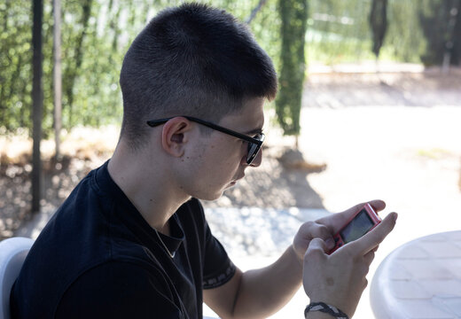 medium shot of a boy playing an old red console