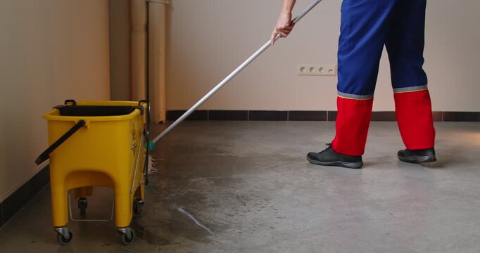 Washing dirty floor, male cleaner housekeeper maid holding mop cleaning at home, doing domestic housework professional household helper at workplace, feet close up, workwear, protective clothing