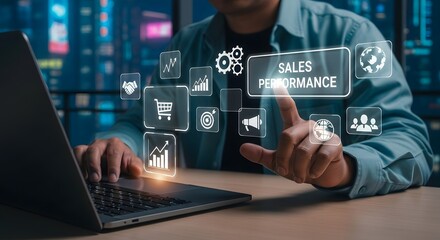 Businessman interacting with a digital interface showing sales performance metrics and business growth icons on a laptop screen in a modern office setting at night