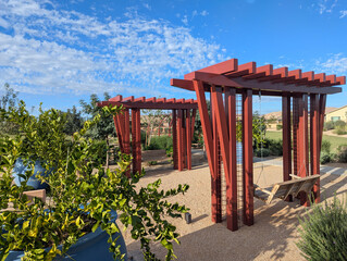 A pair of tandem swings under pergolas at a public park